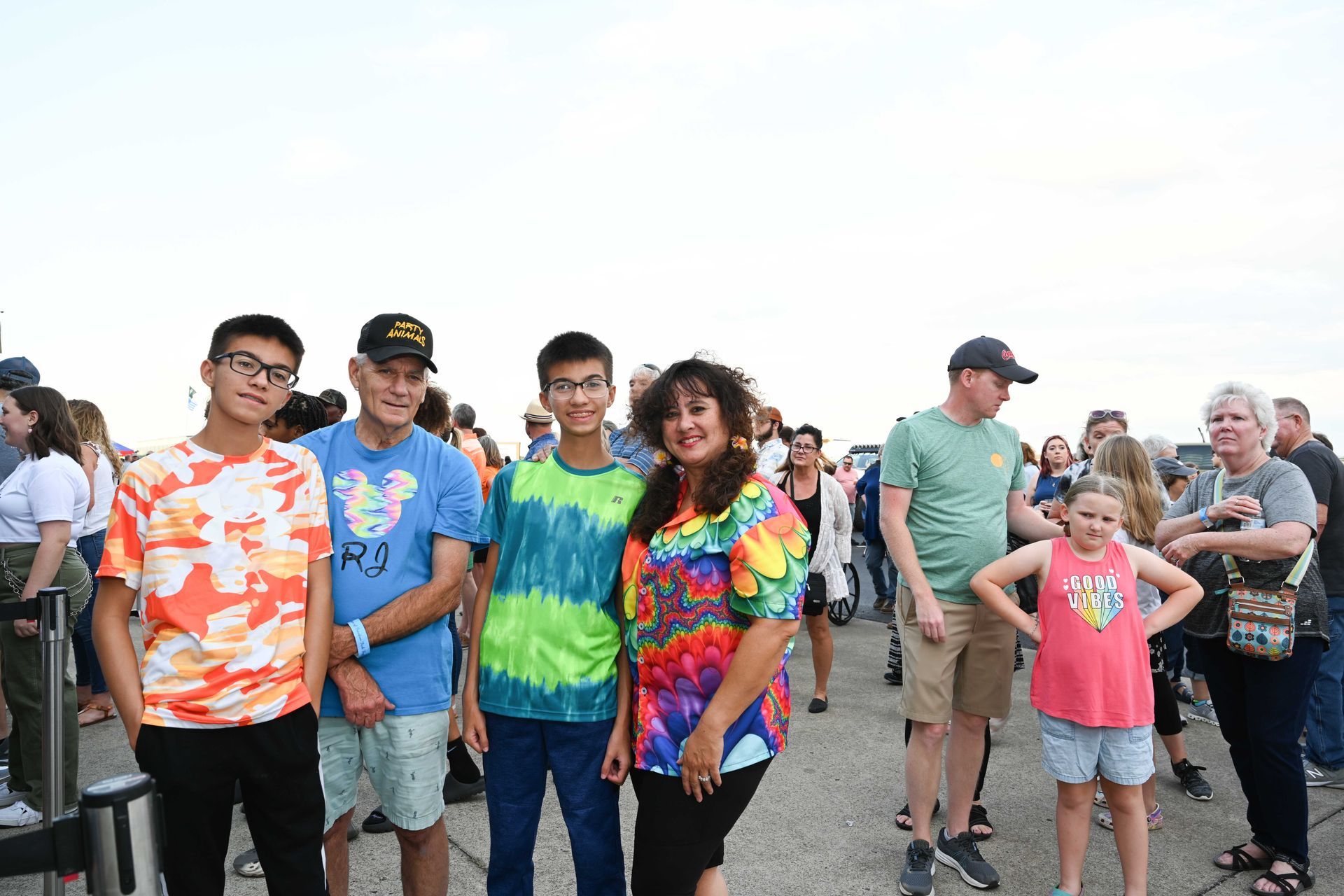 A group of people standing next to each other on a sidewalk.