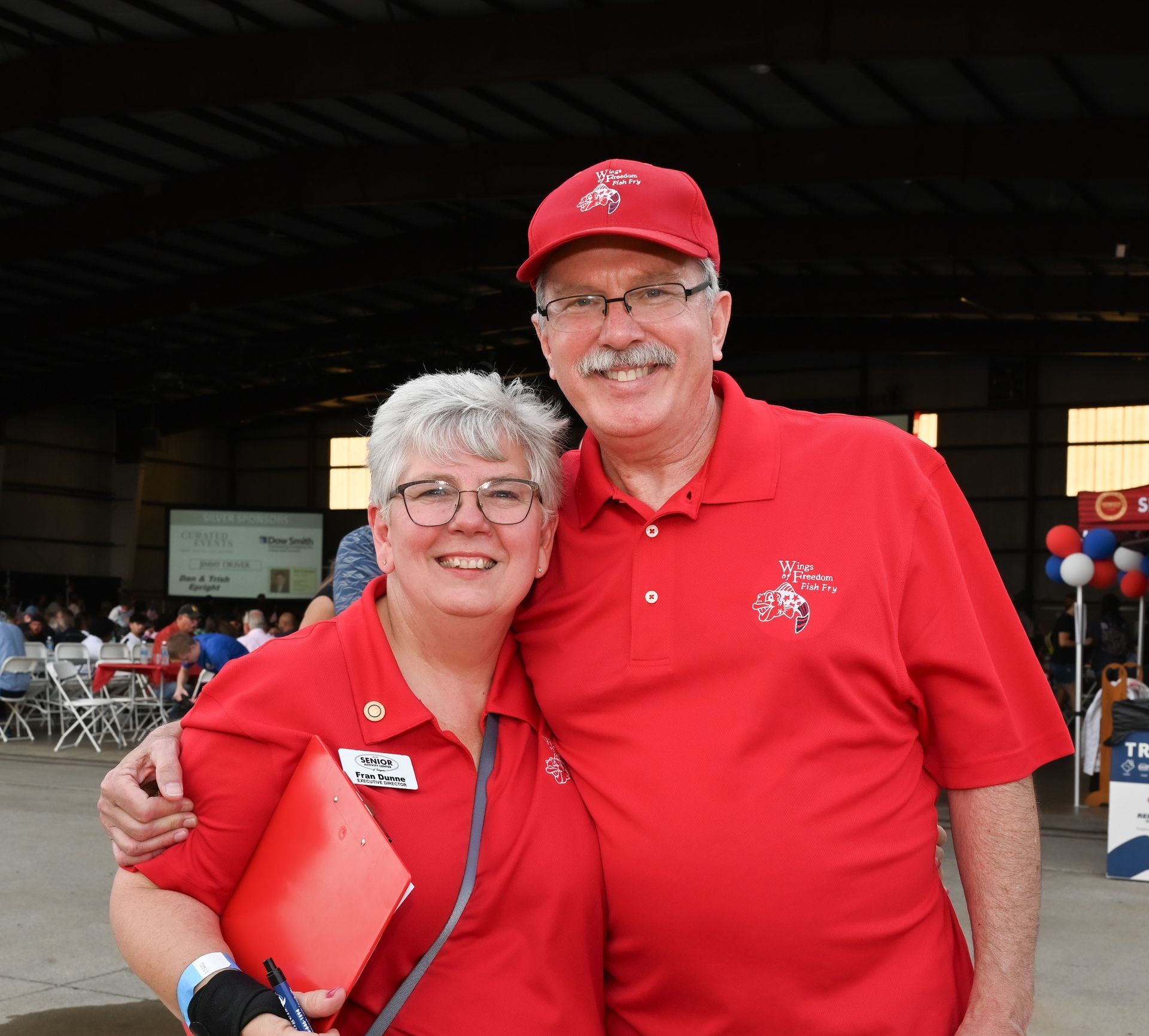 A man and a woman in red shirts are posing for a picture
