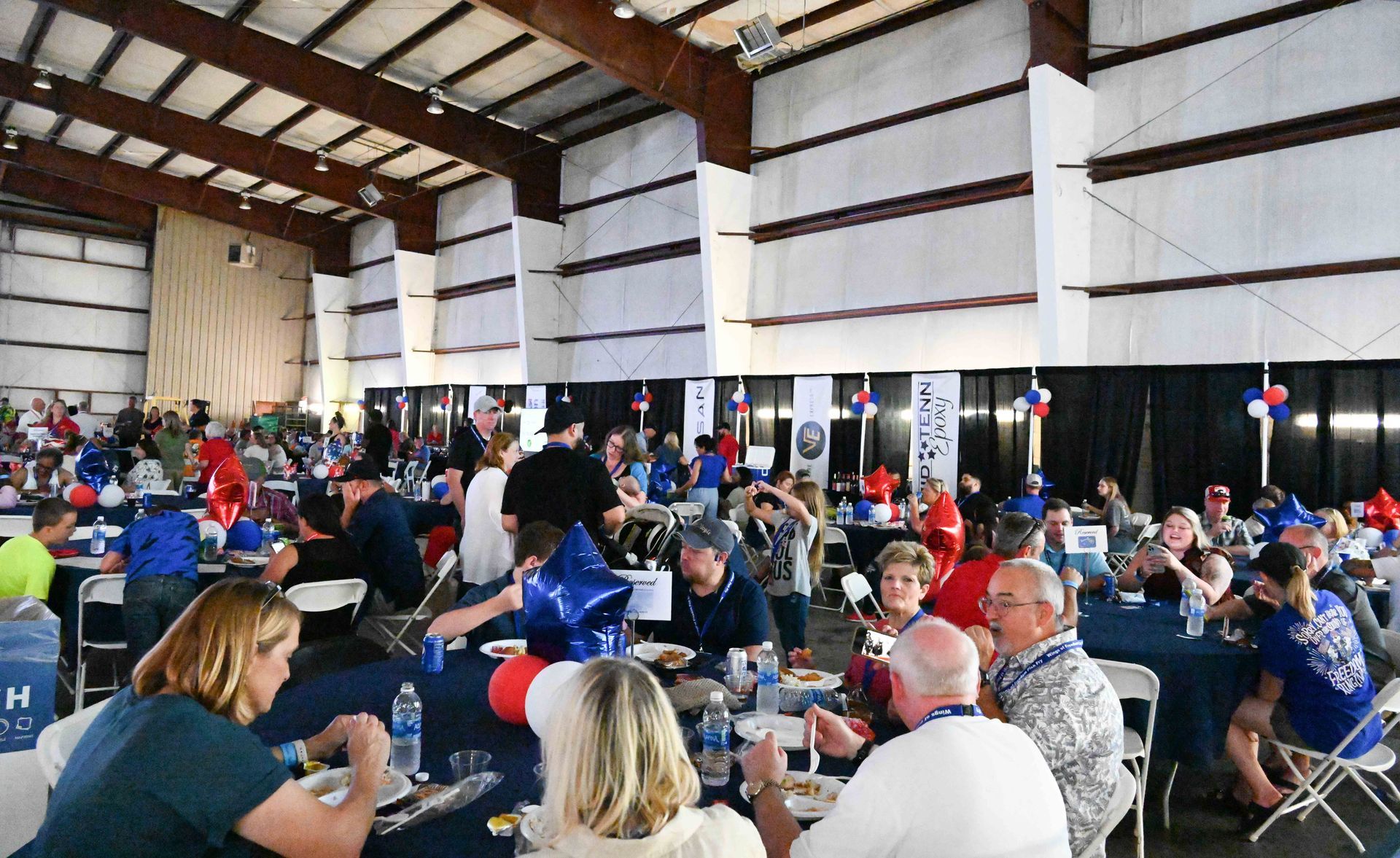 A large group of people are sitting at tables in a large room.