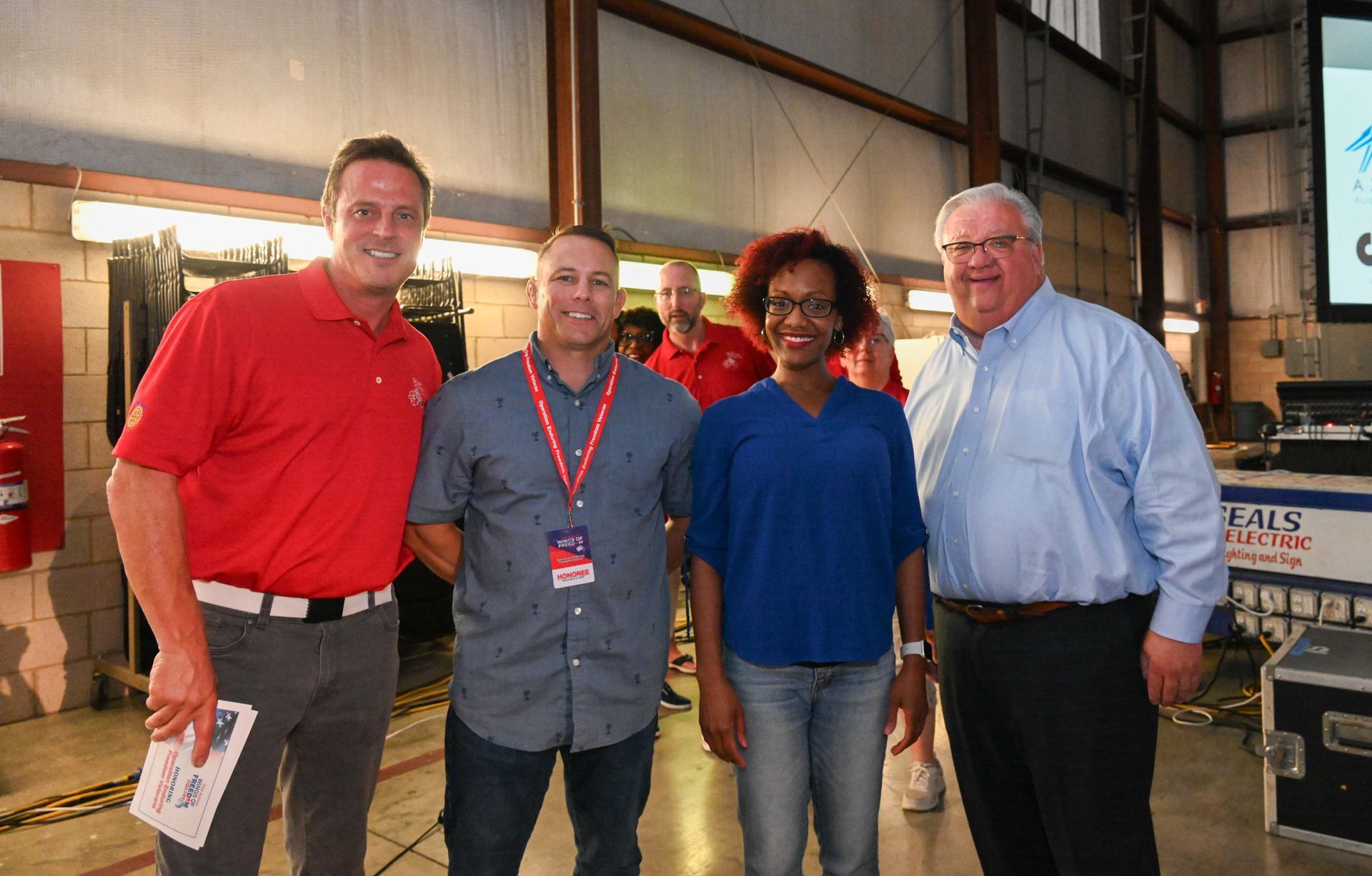 A group of people are posing for a picture in a warehouse.