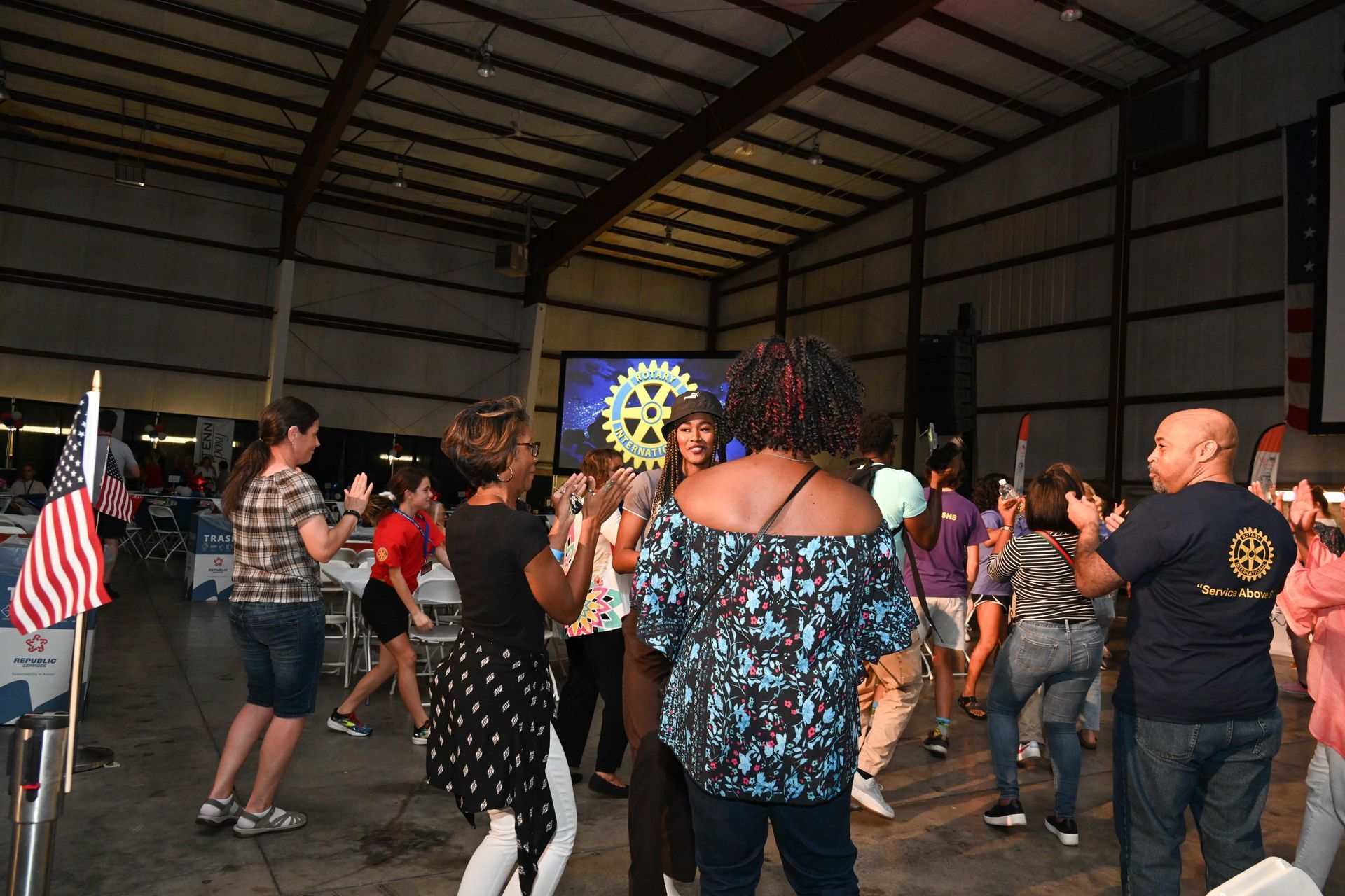 A group of people are dancing in a large room.