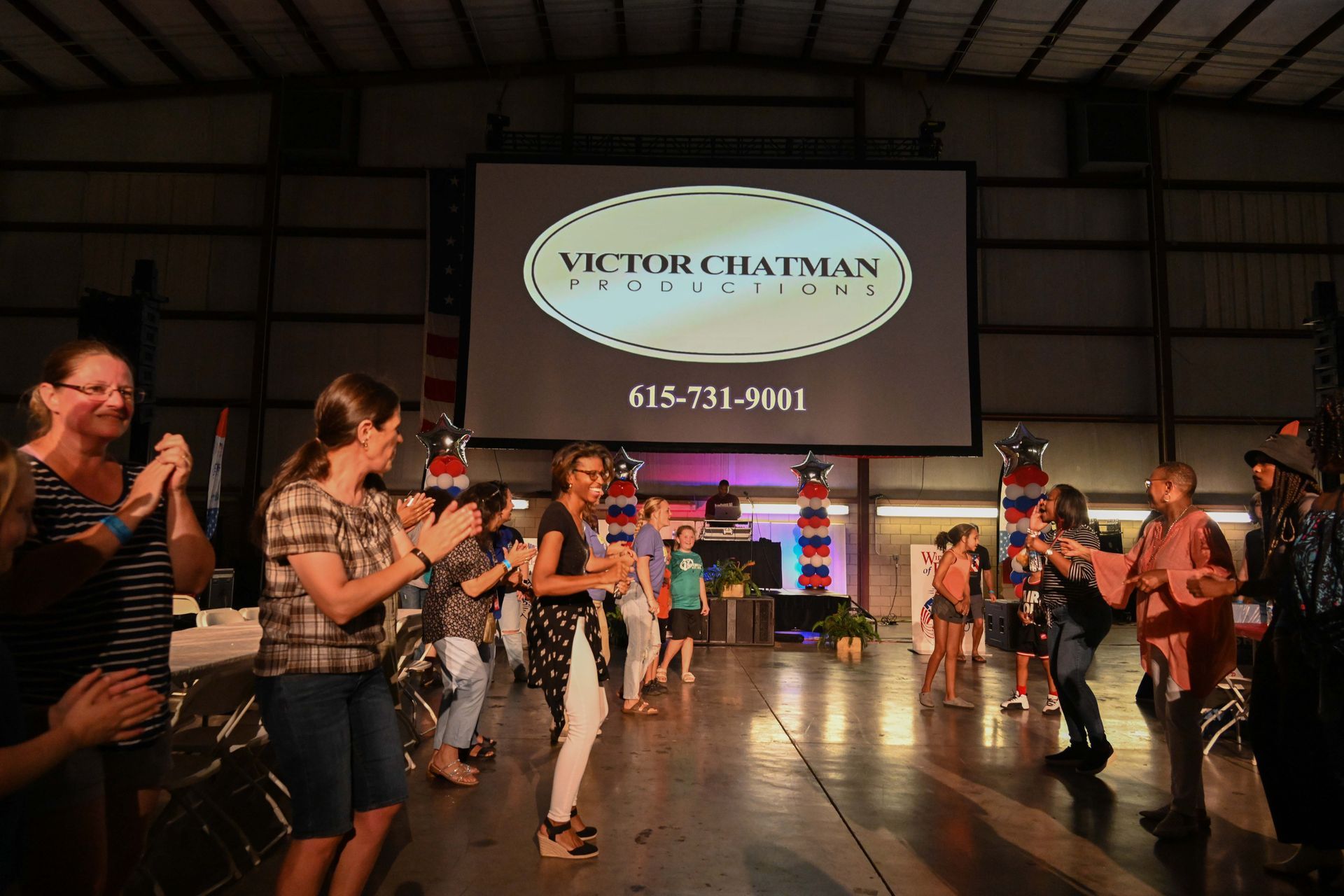 A group of people are dancing in front of a screen that says victor craftsman