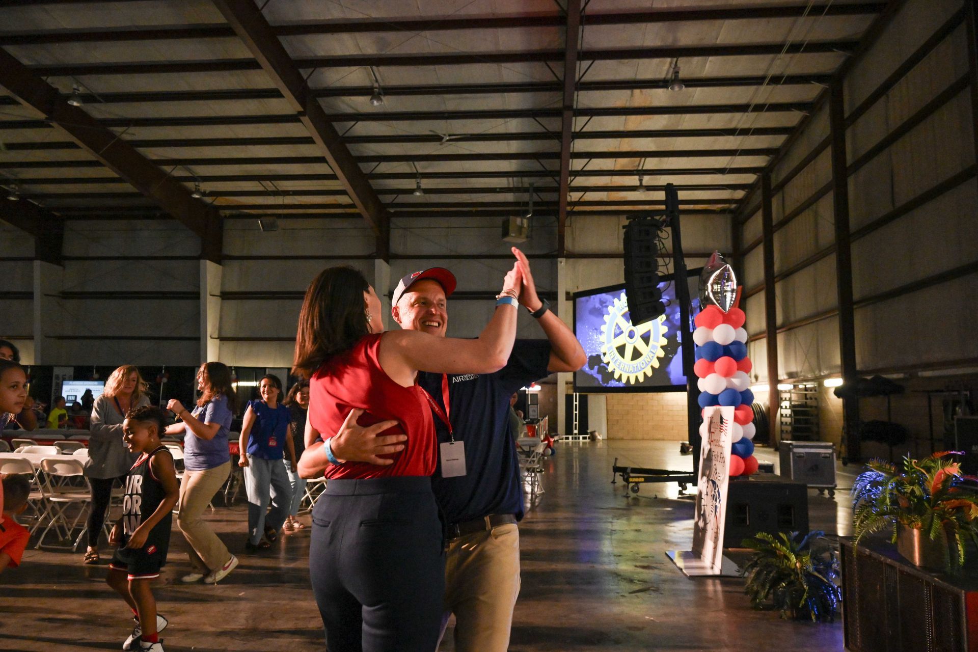 A group of people are dancing in a large room.