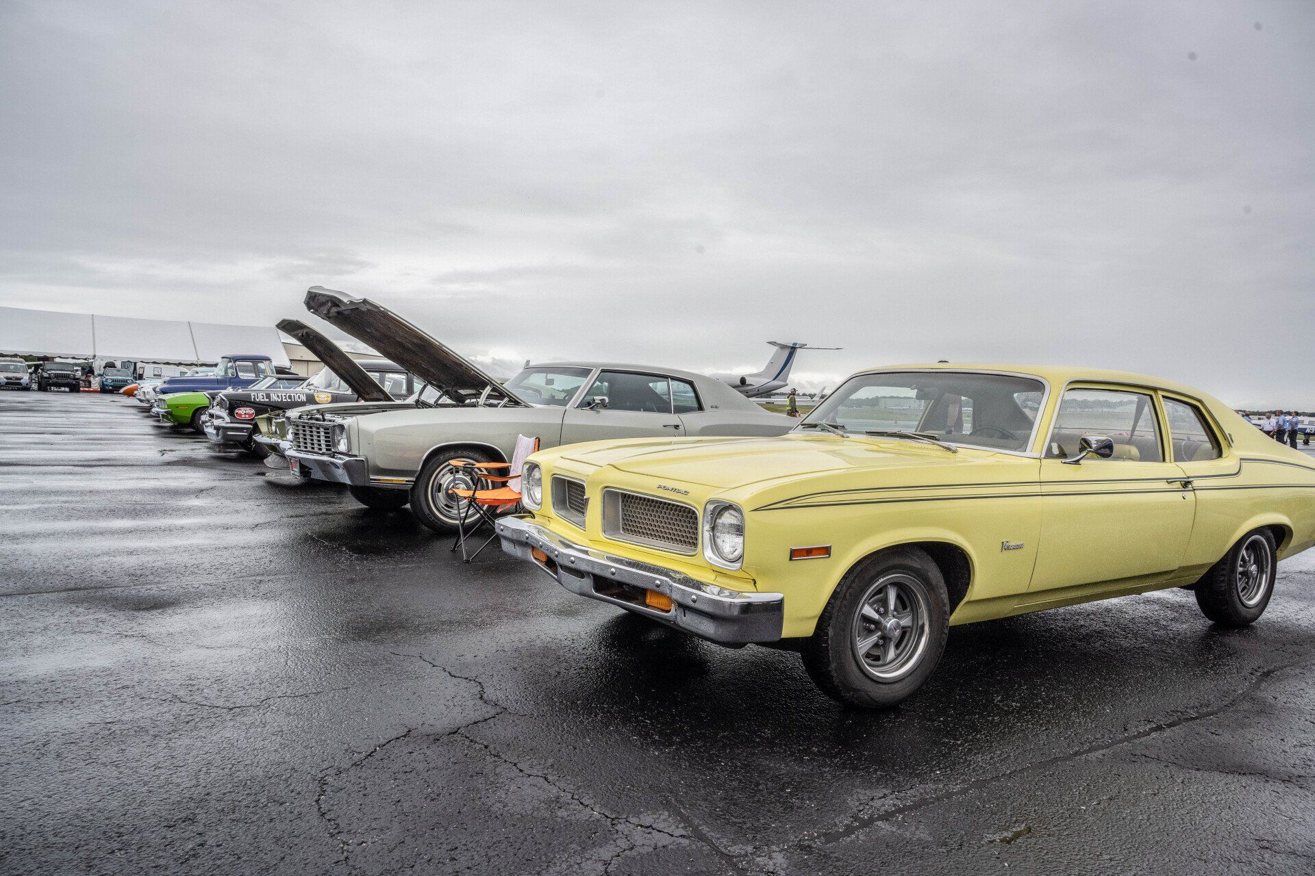 A yellow car is parked next to a white car in a parking lot.