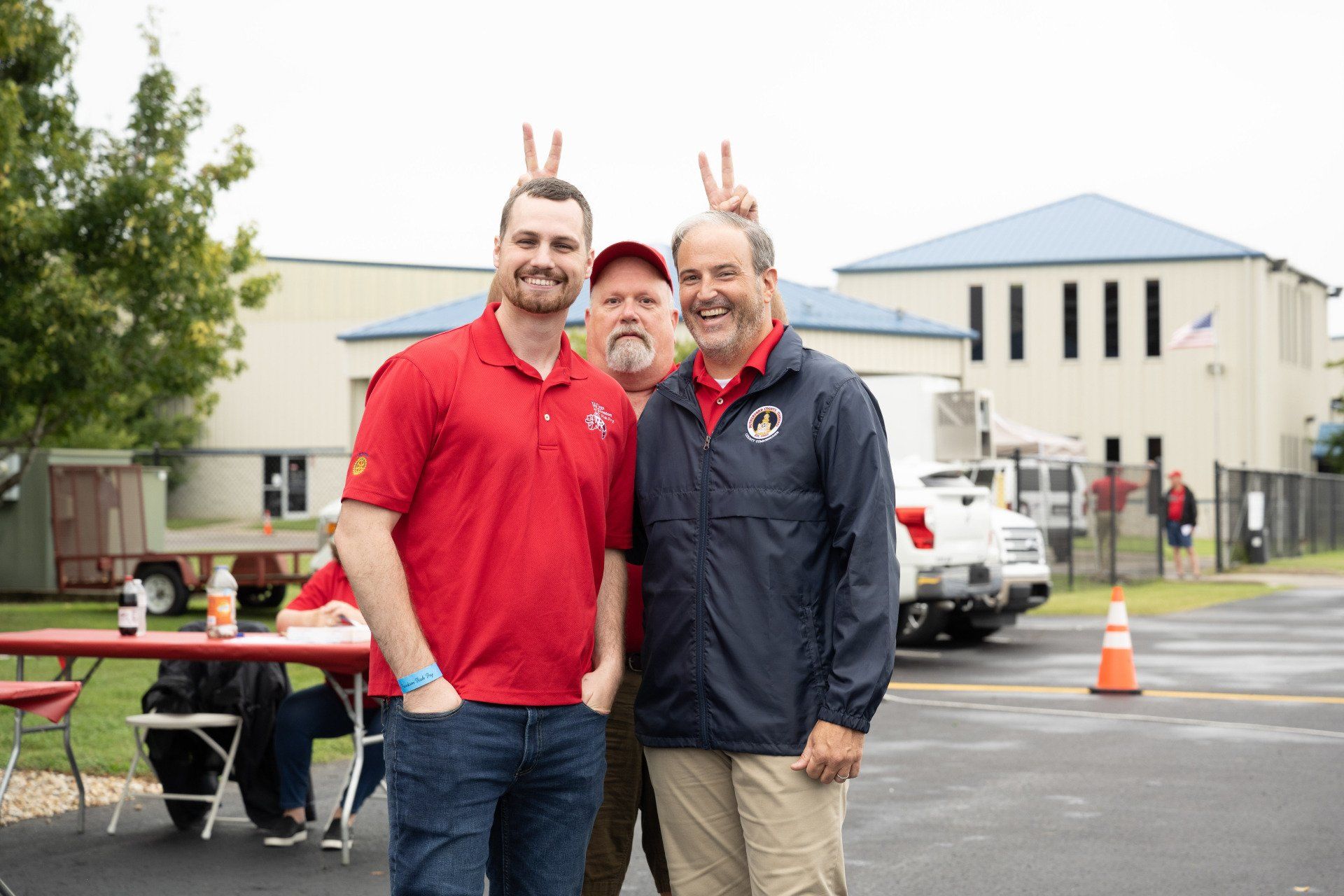 Three men are posing for a picture in front of a building.