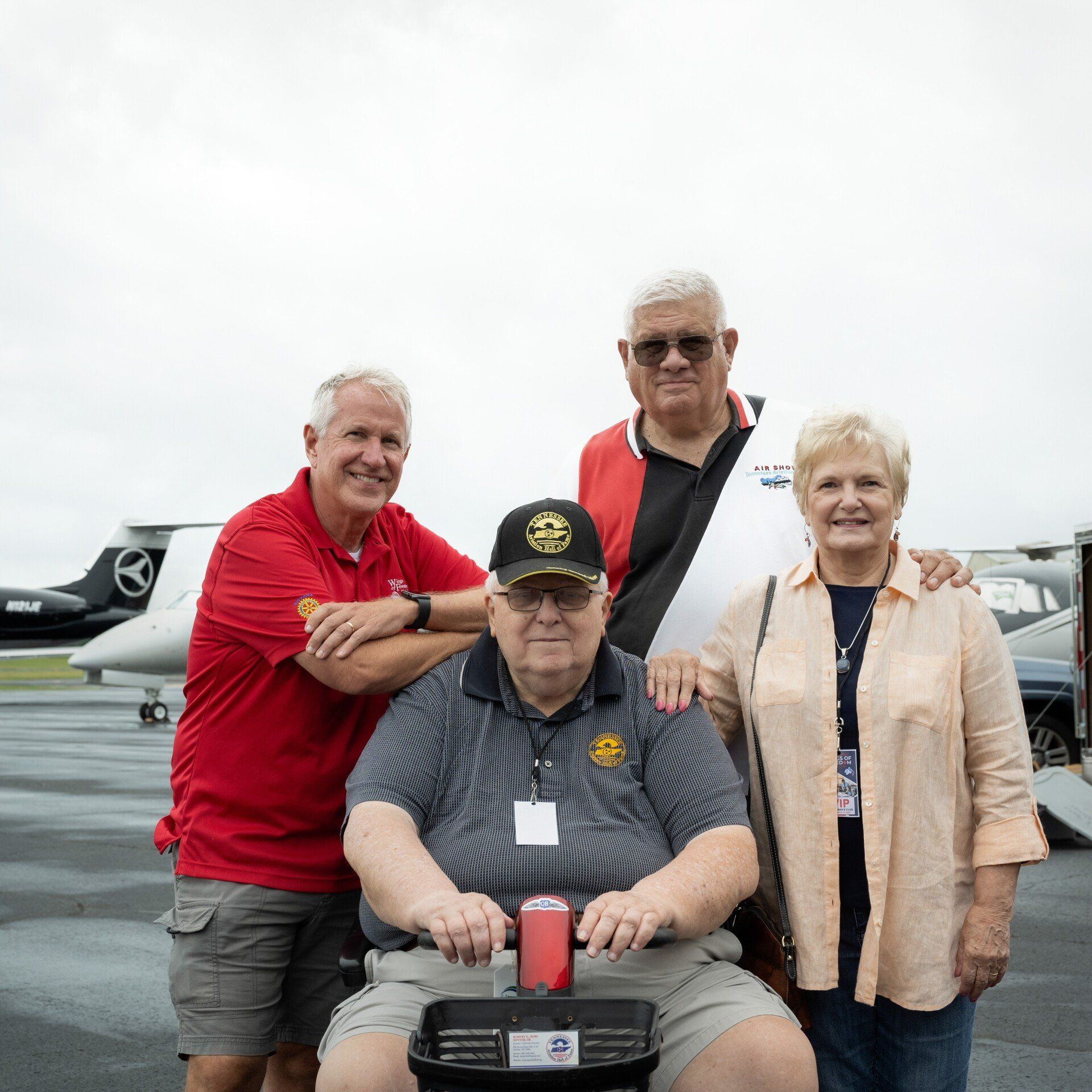 A group of people posing for a picture with a man in a wheelchair