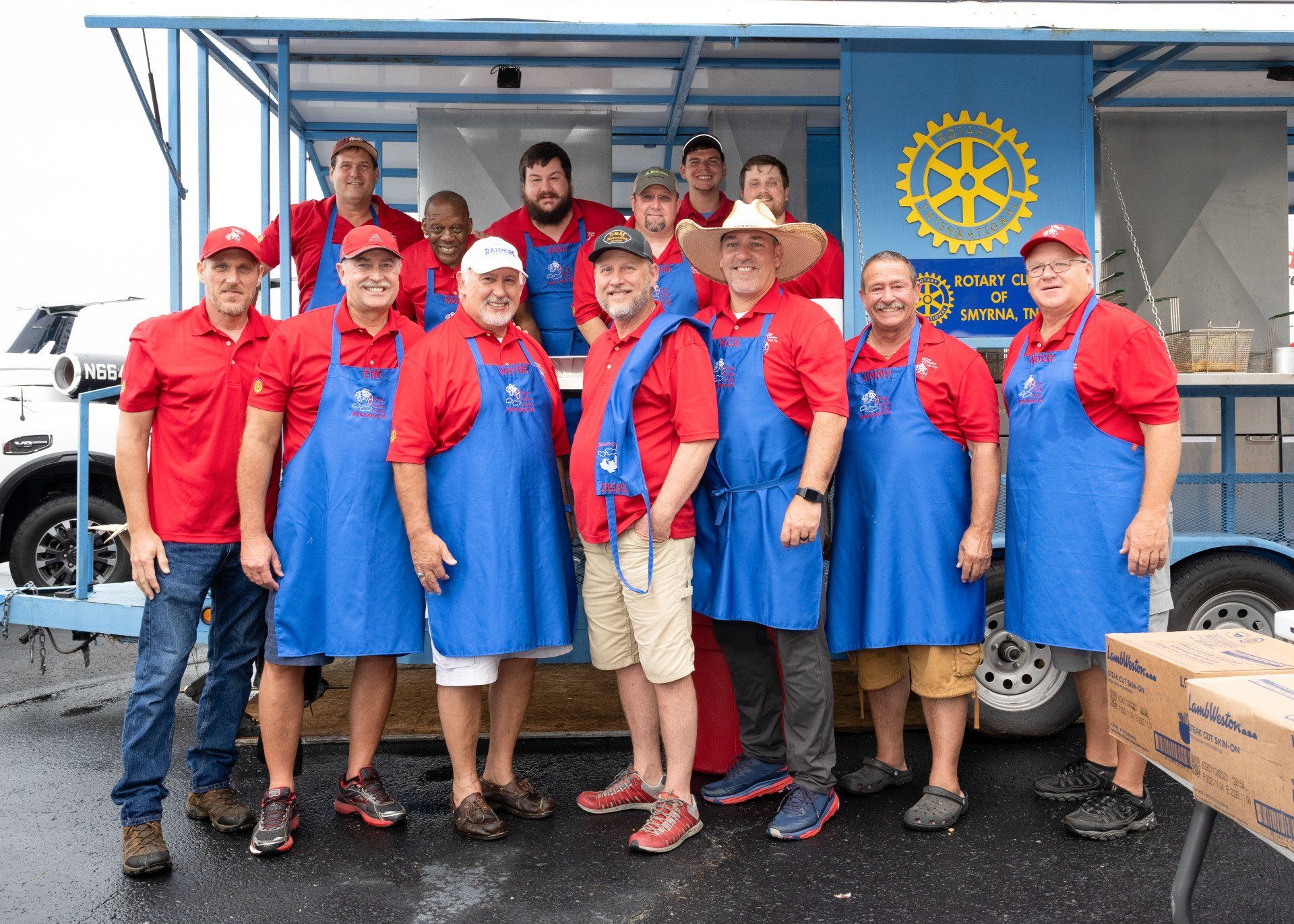 A group of men are posing for a picture in front of a food truck.