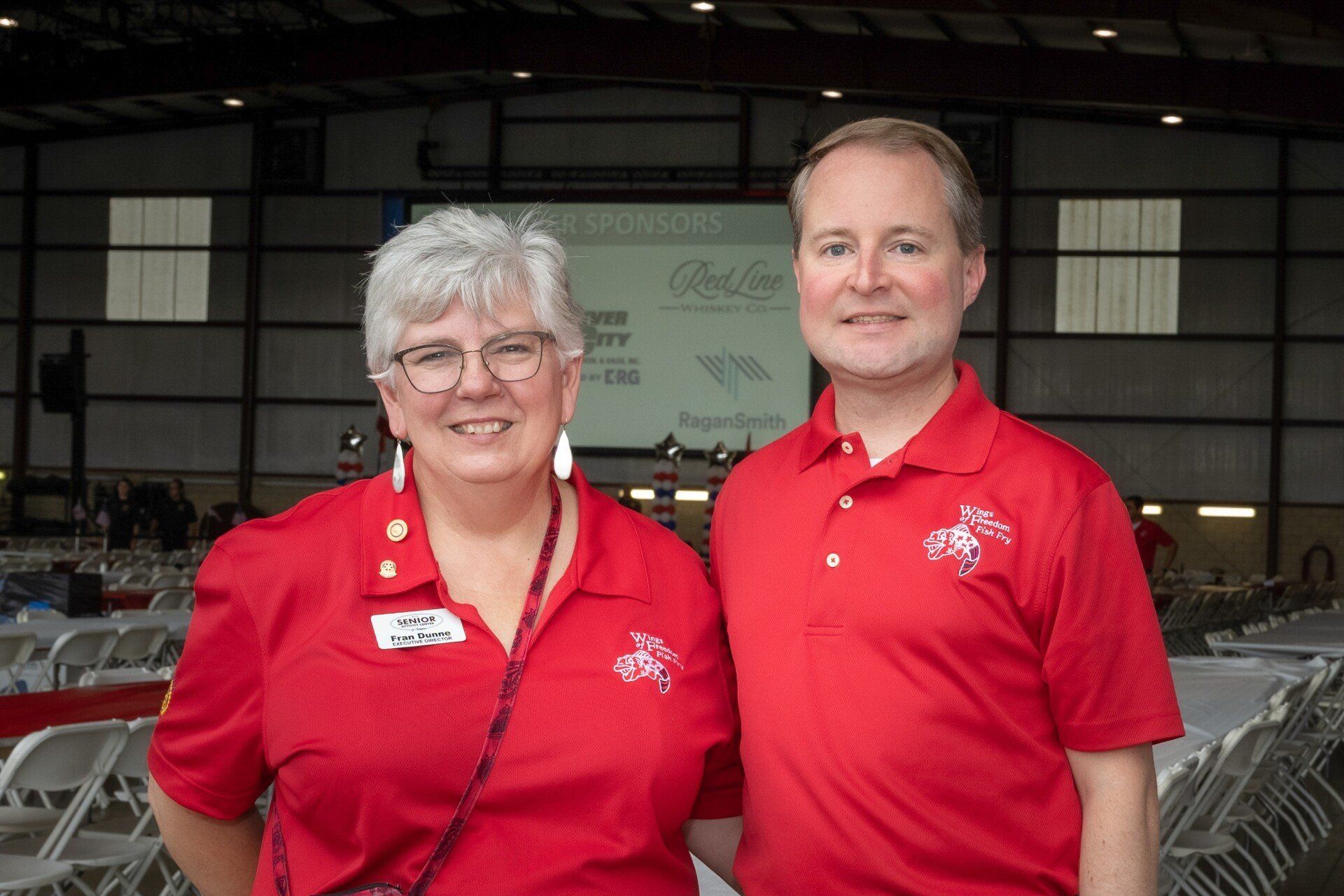 A man and a woman in red shirts are posing for a picture.