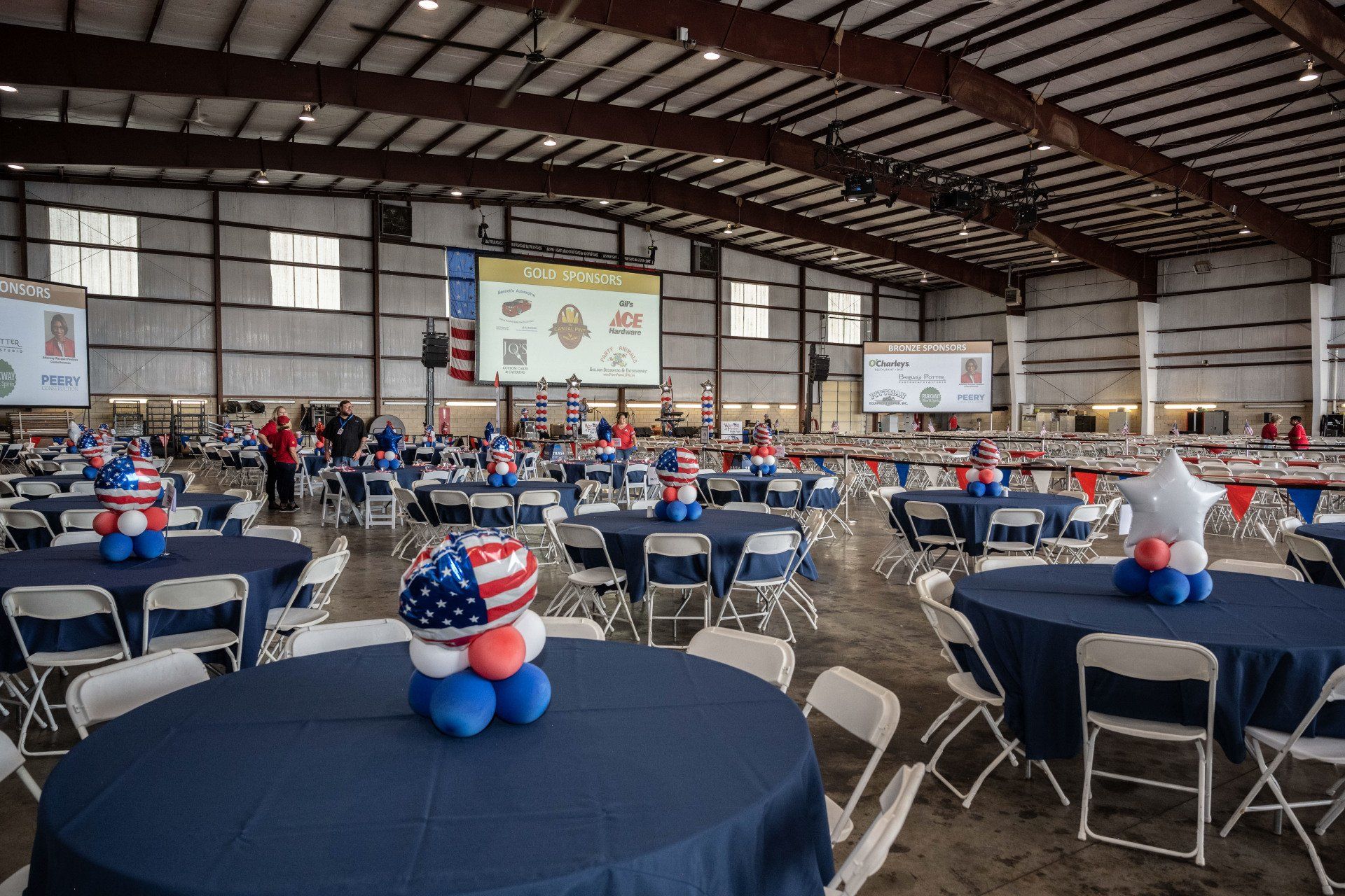 A large room filled with tables and chairs decorated with balloons.