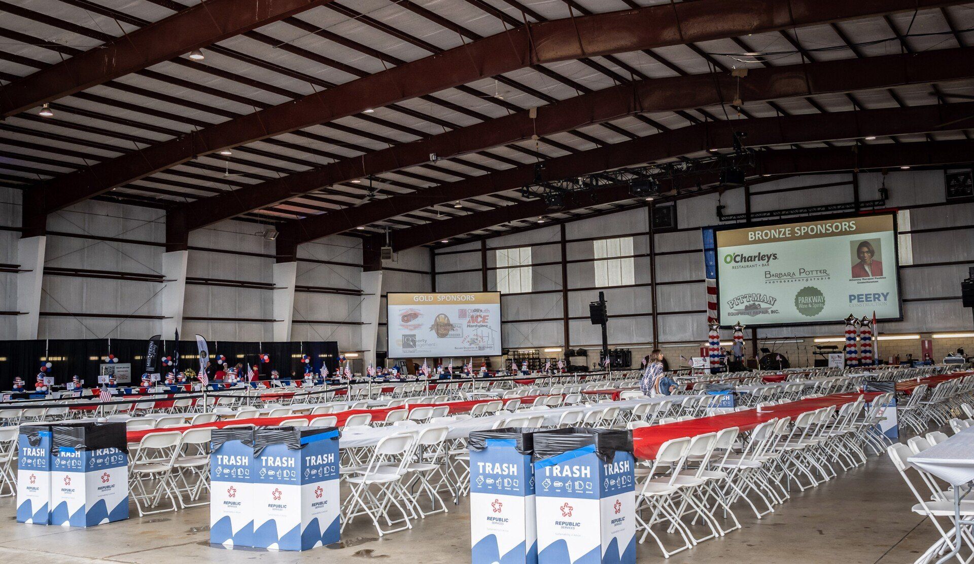 A large room with tables and chairs and a large screen