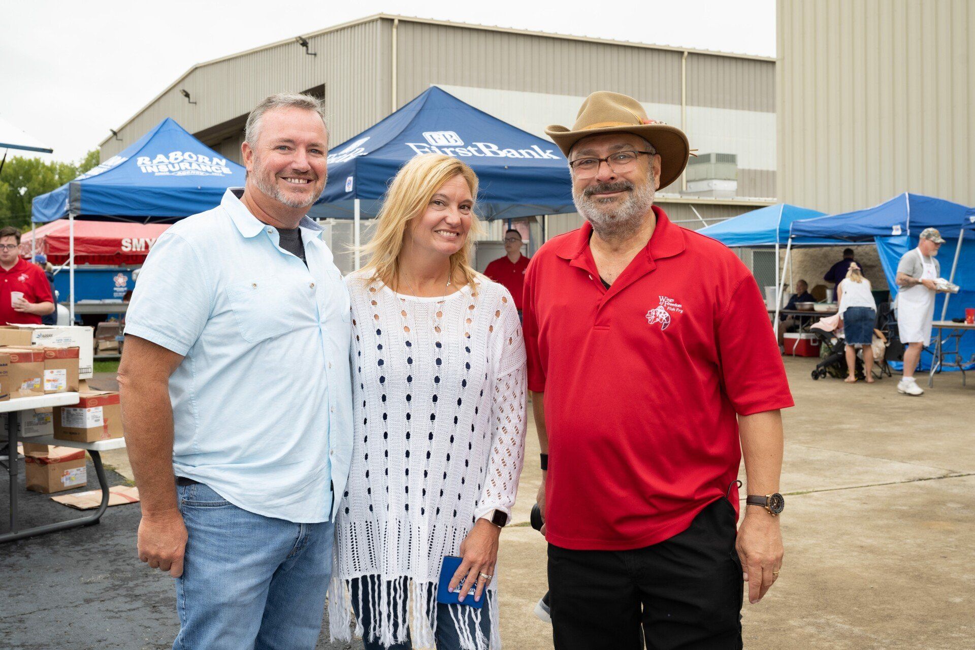 Three people are posing for a picture in front of a building.