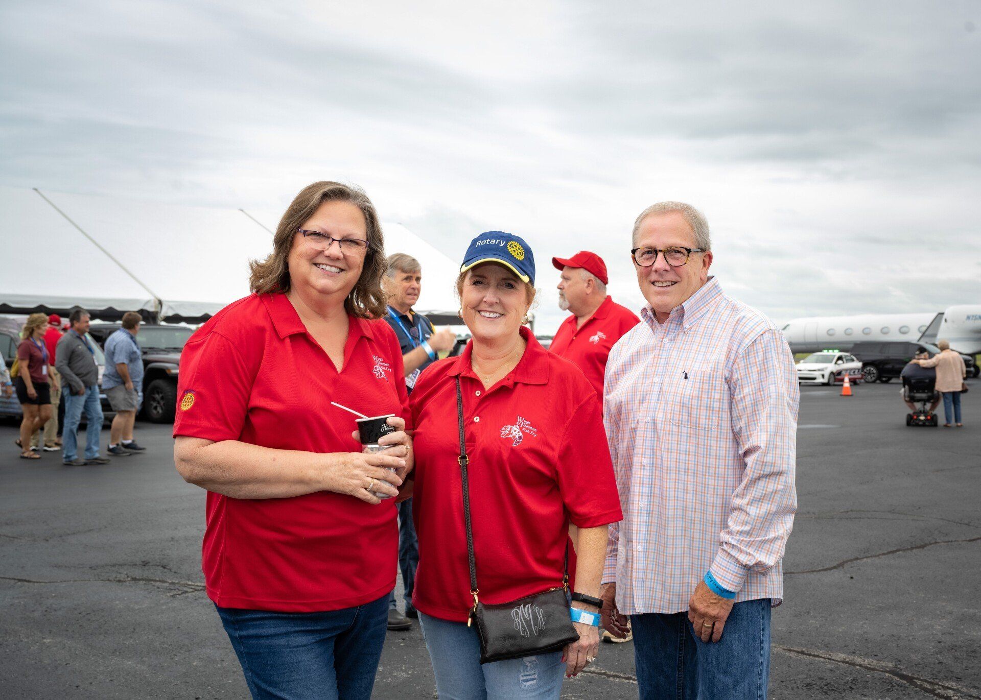 A group of people are standing next to each other on an airport tarmac.