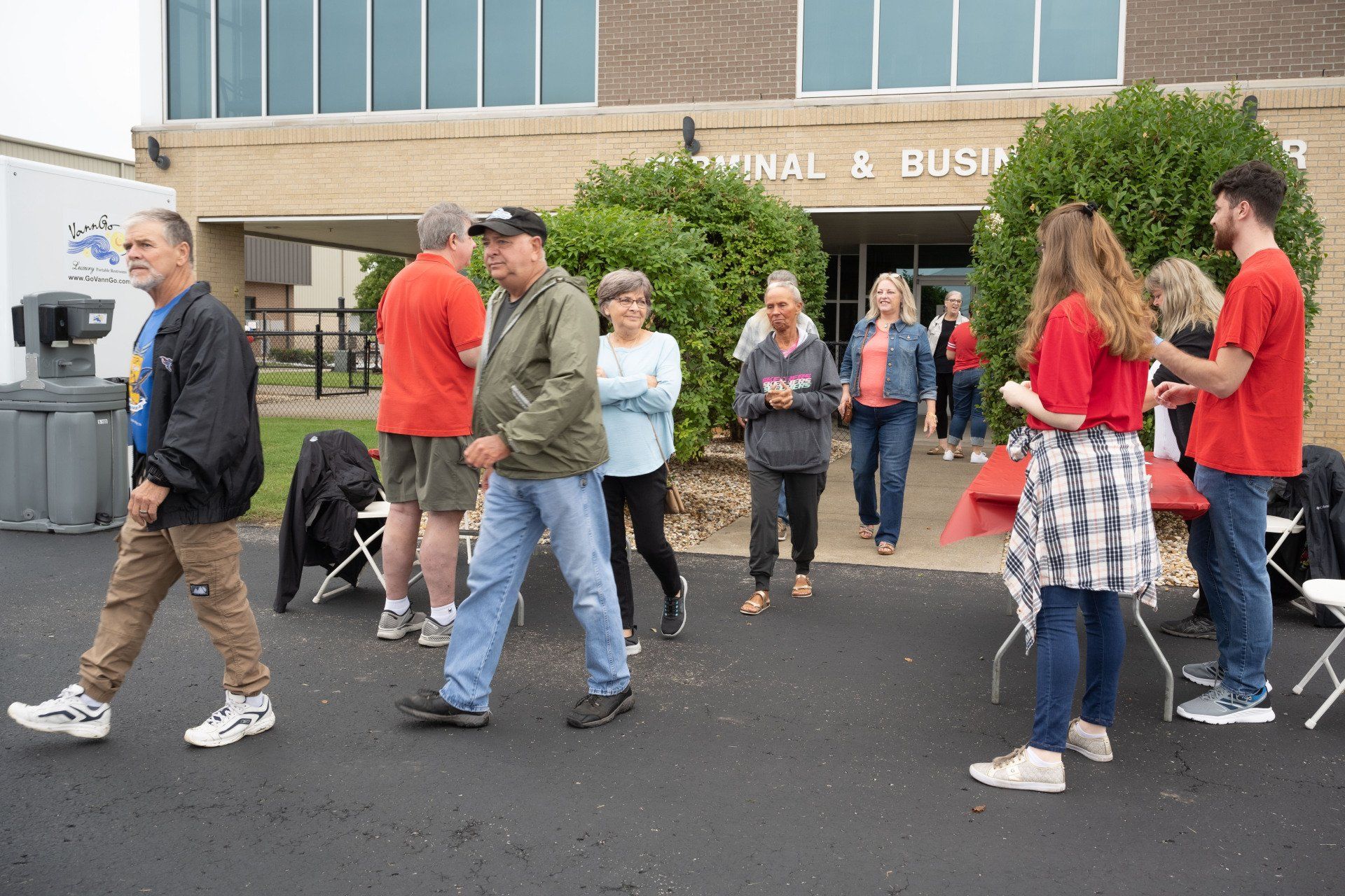 A group of people are walking in front of a building.