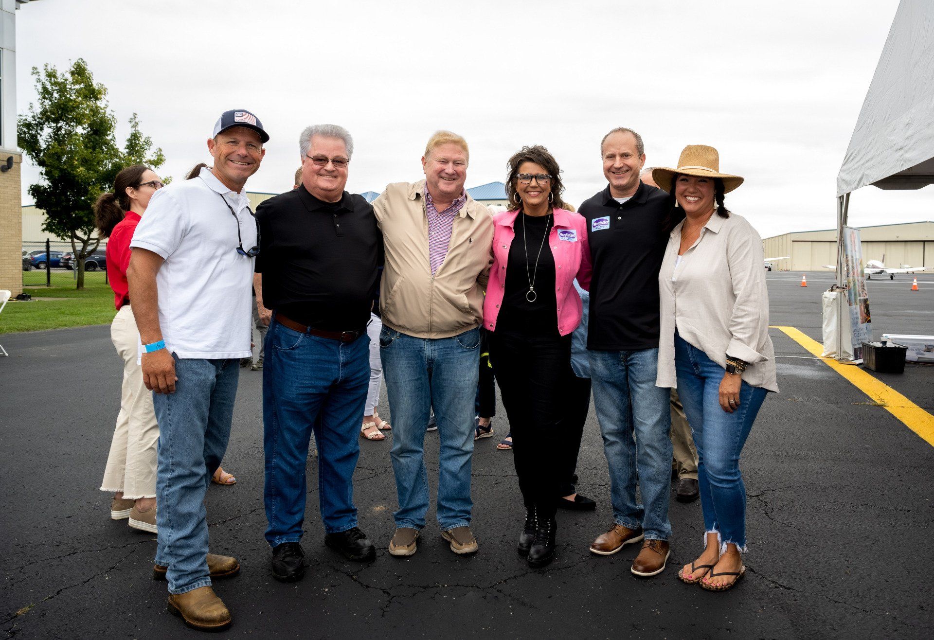 A group of people are posing for a picture in a parking lot.