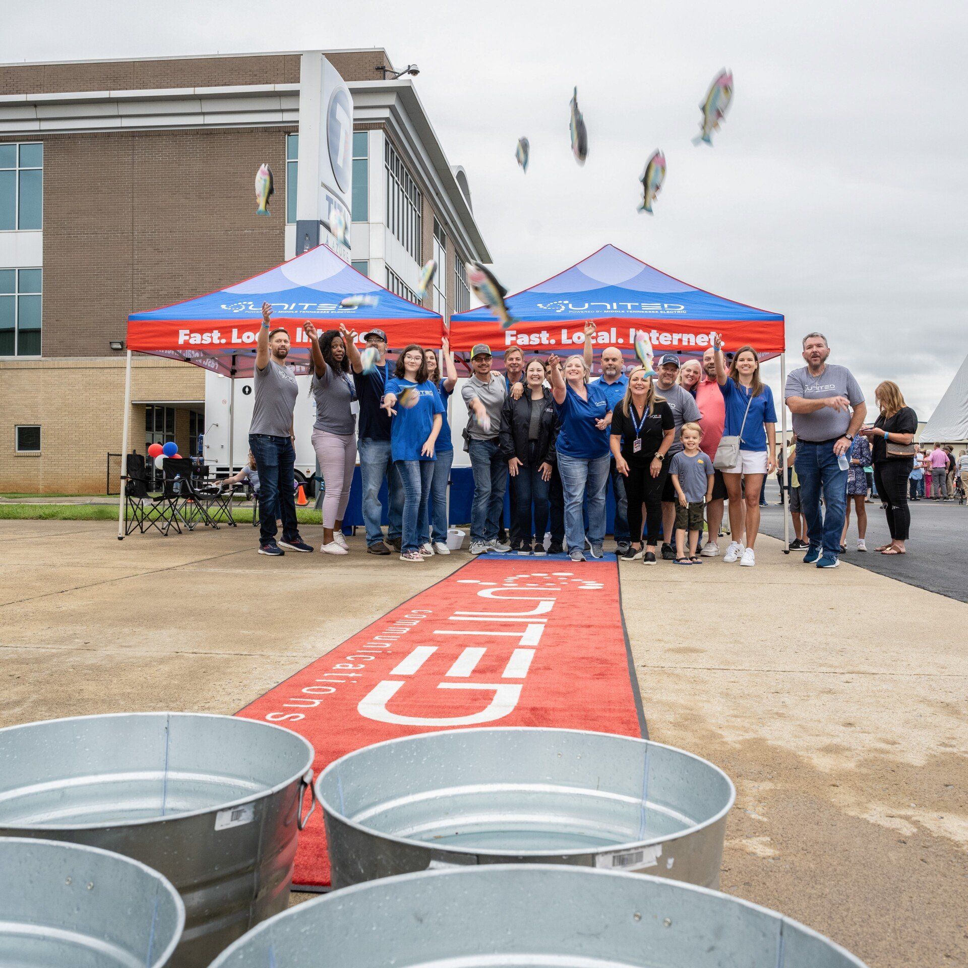 A group of people standing in front of buckets that say united
