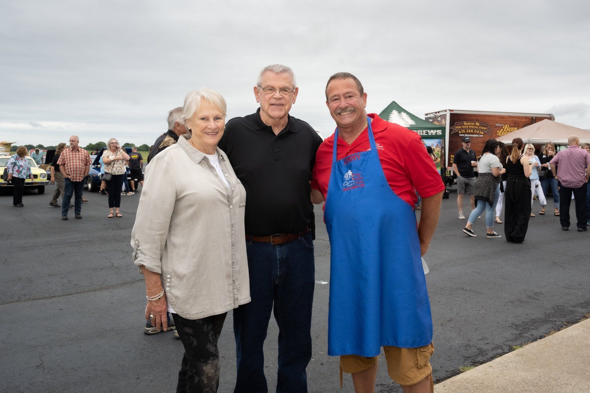 A group of people are posing for a picture in a parking lot.