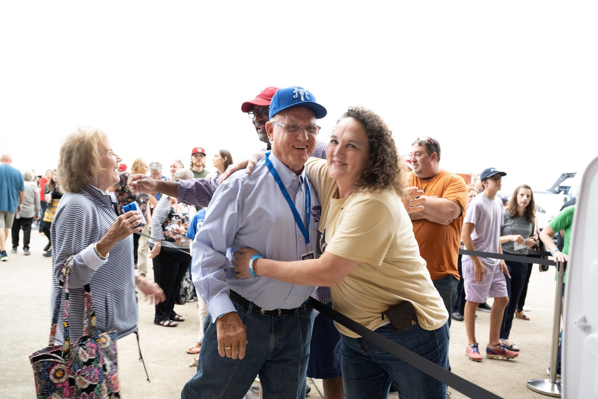 A woman is hugging a man in a crowd of people.