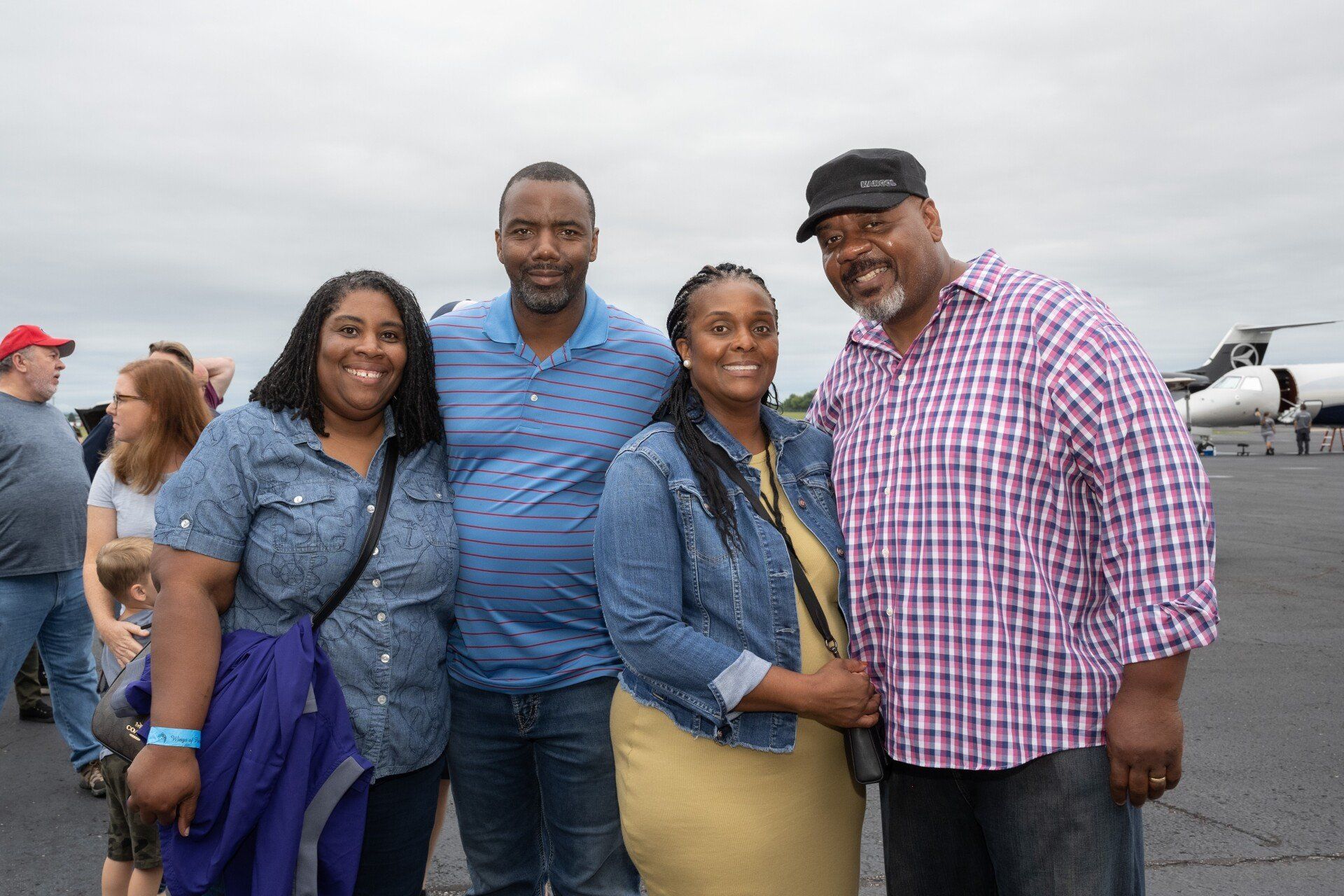A group of people are posing for a picture in front of a plane.