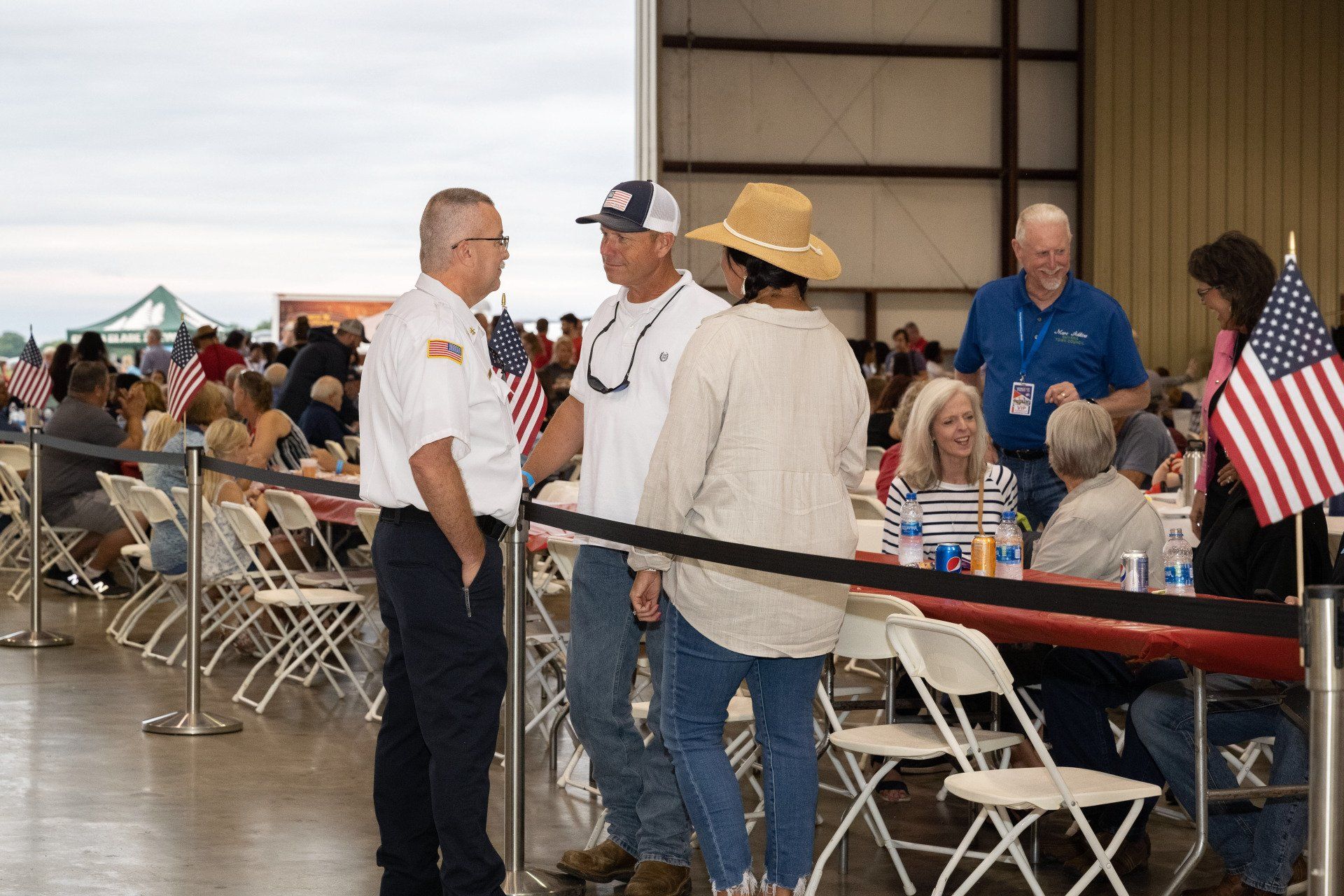 A group of people are standing in a room talking to each other.