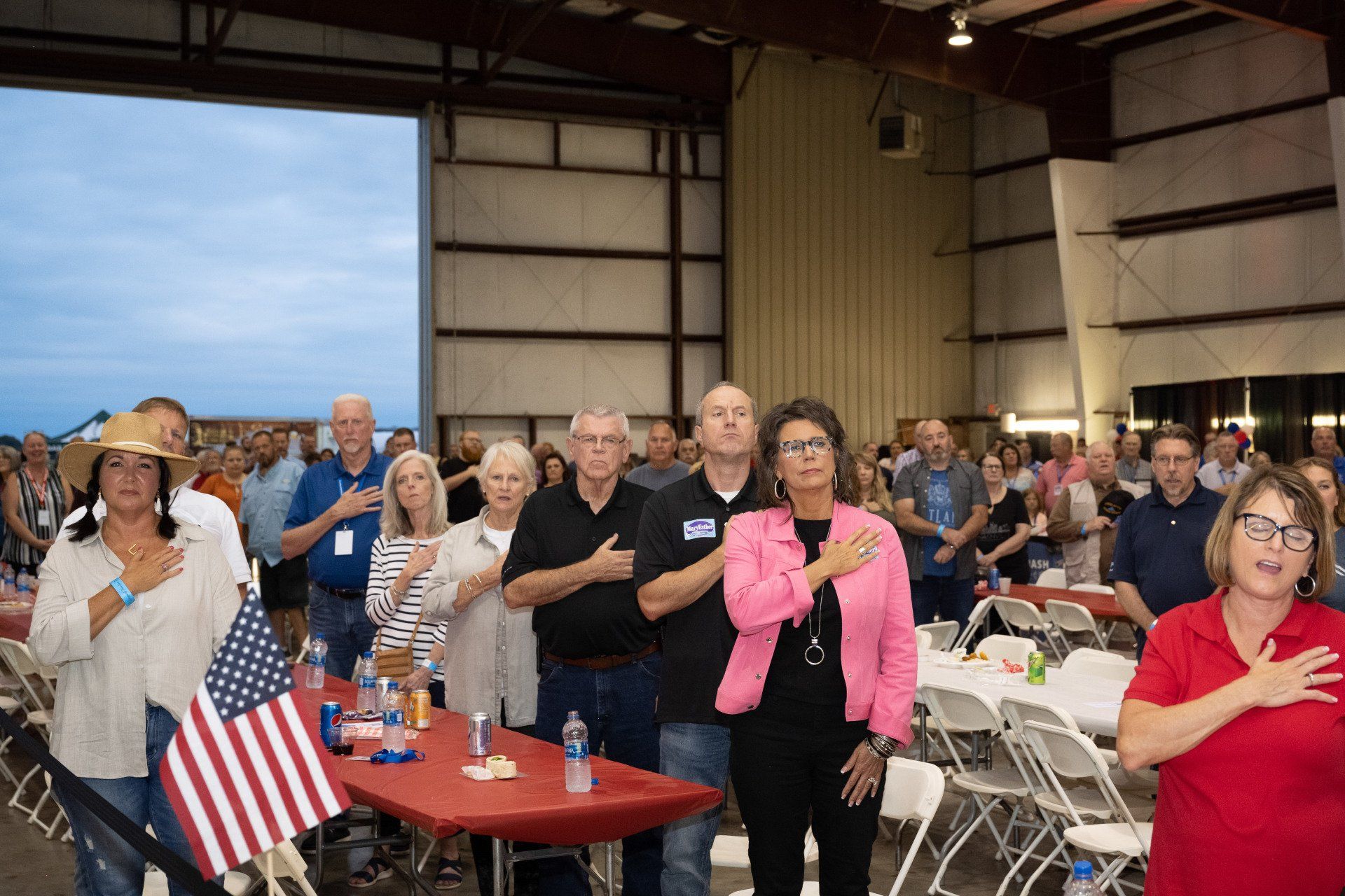 A group of people are standing in a room with their hands on their chests.