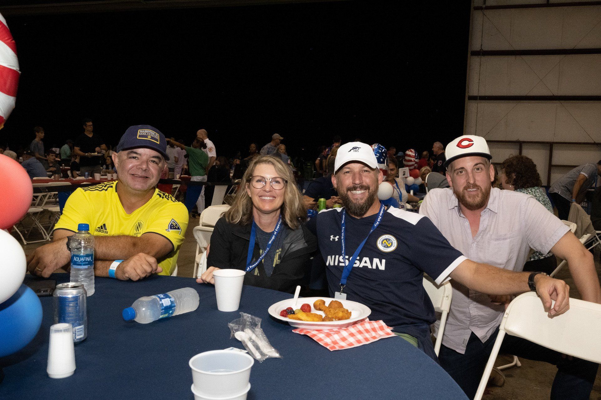 A group of people are sitting at a table with plates of food.