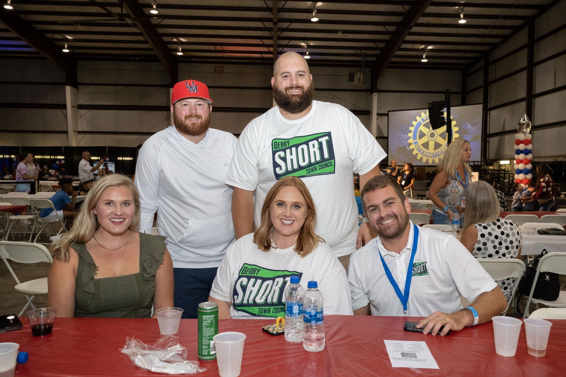 A group of people are sitting at a table posing for a picture.