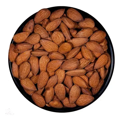 Cuenco de almendras tostadas, de color marrón y forma ovalada, en un recipiente negro.