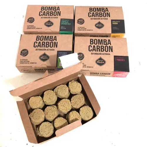 Cajas de briquetas de carbón activado “Bomba Carbon”, con una de las cajas abierta para exponer las briquetas.