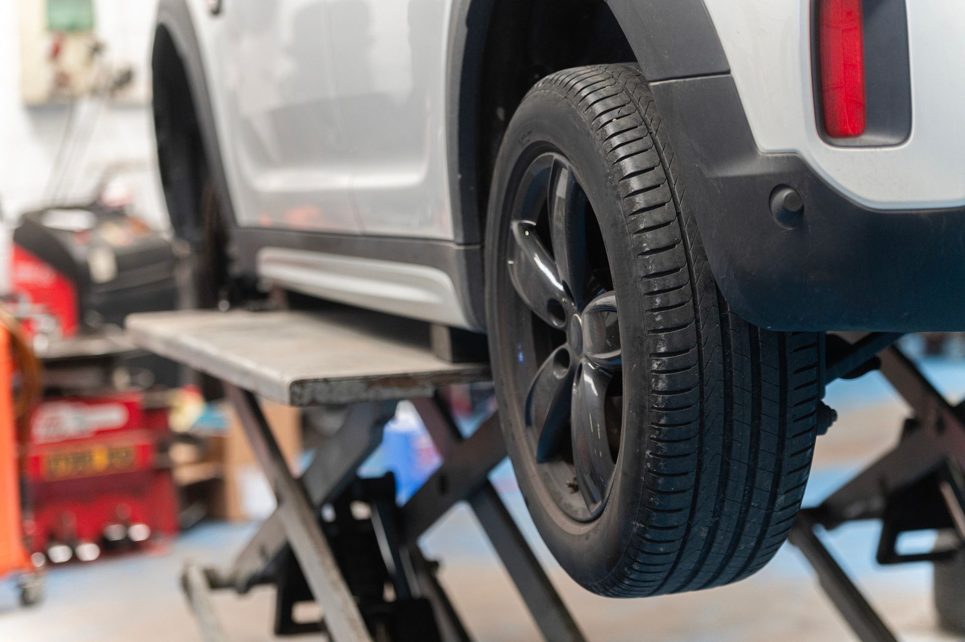 A car is sitting on a lift in a garage.