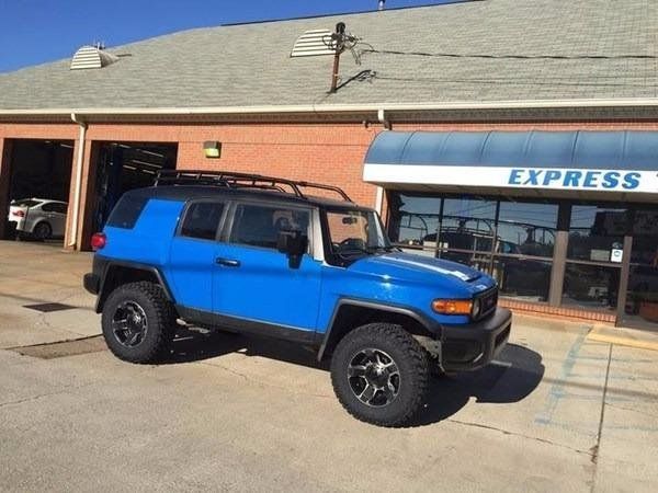 A blue toyota fj cruiser is parked in front of express A blue toyota fj cruiser is parked in front of express