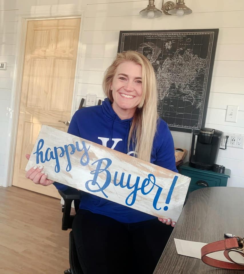A woman is holding a sign that says `` happy buyer ''.