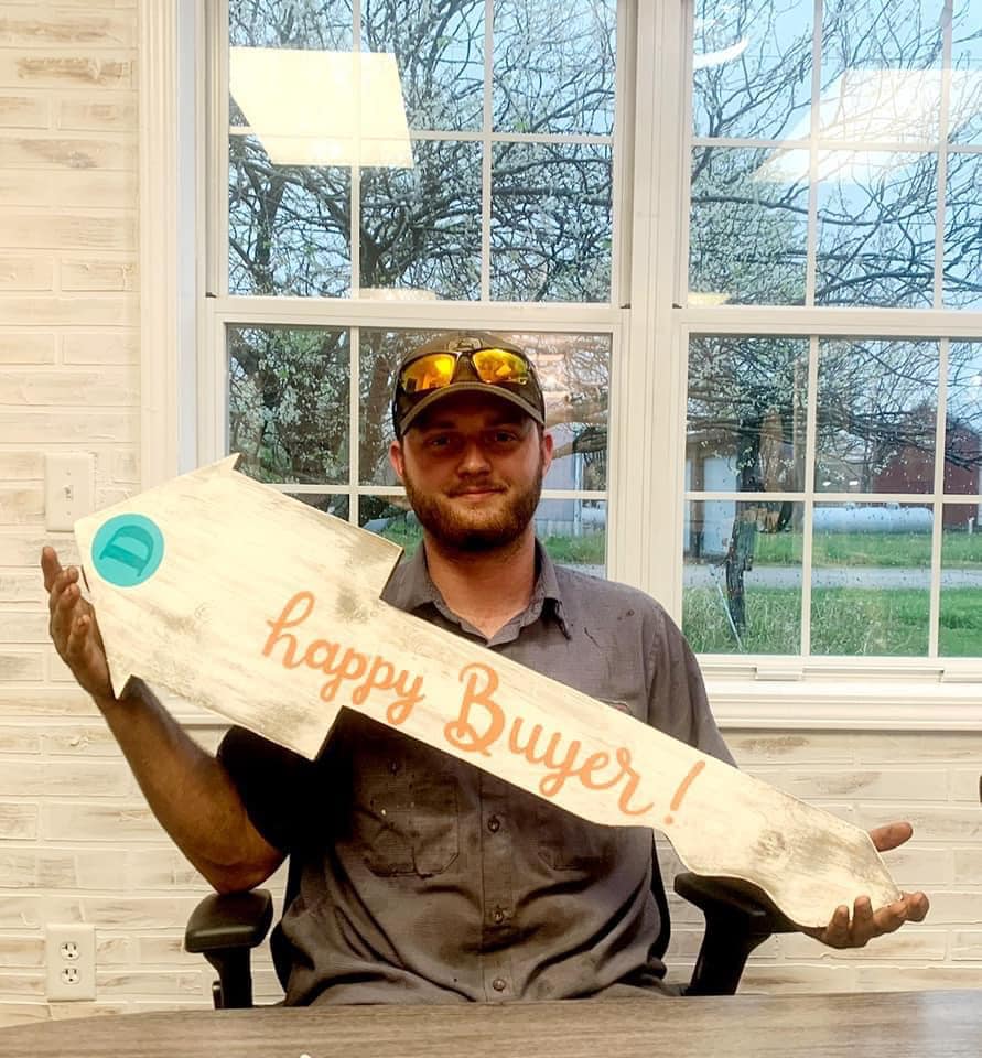 A man is holding a sign that says happy buyer