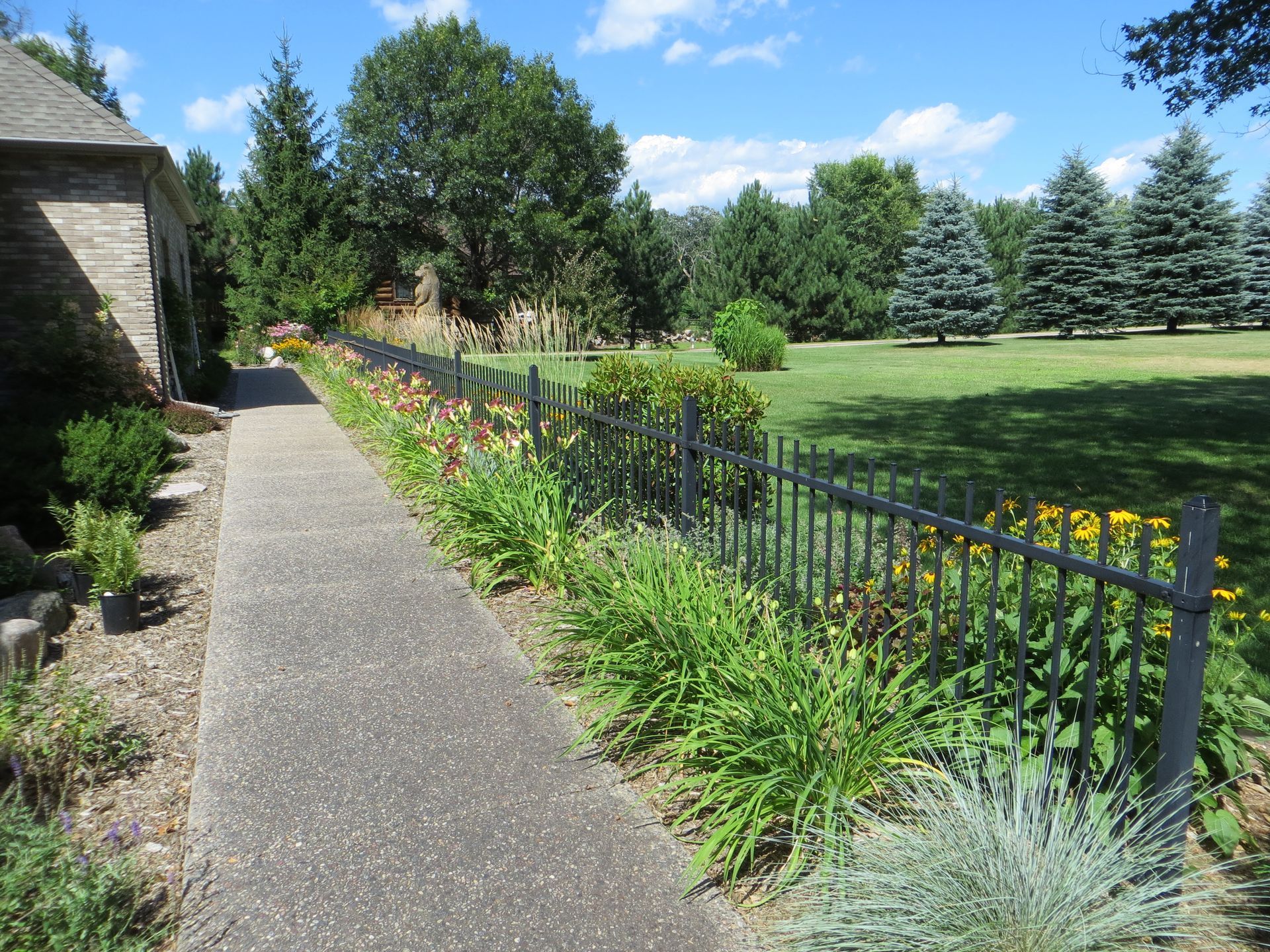 A path leading to a house with a fence surrounding it