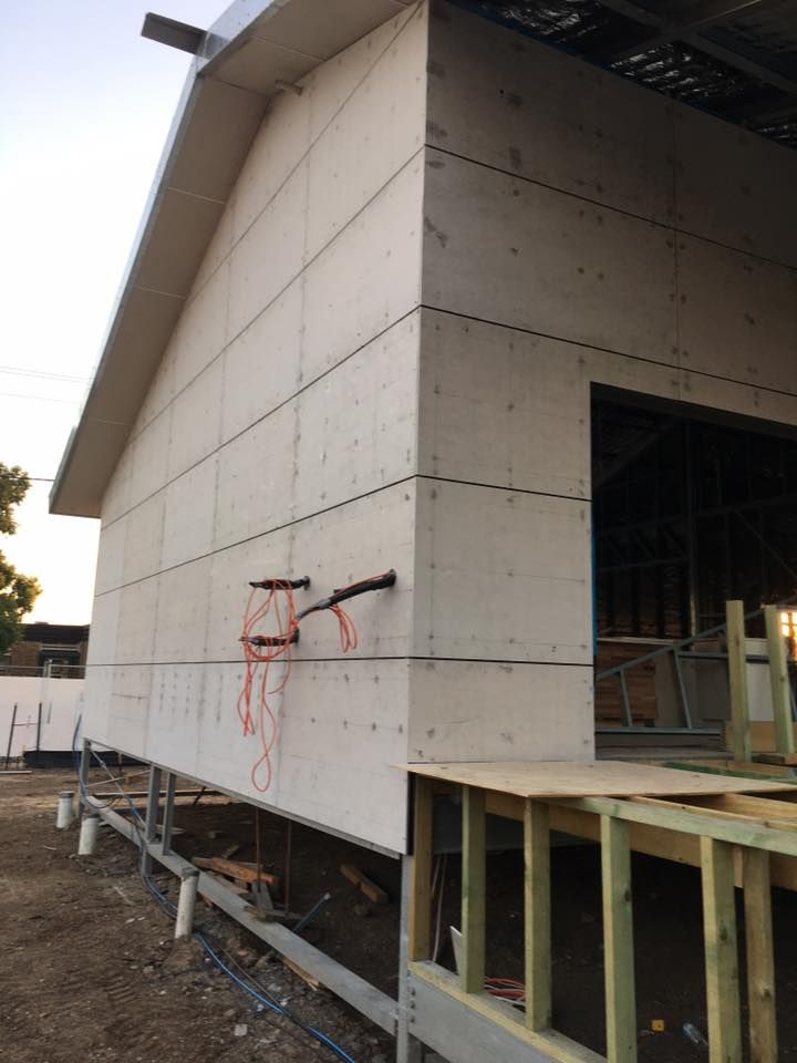 A House is Being Built With a Lot of Wires Hanging From the Side of It — LVL Constructions in Newcastle, NSW
