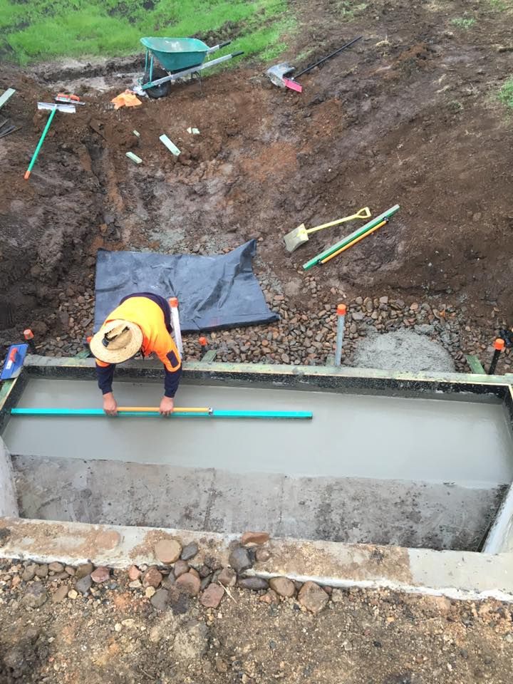 A Construction Worker is Leveling Concrete in a Hole — LVL Constructions in Newcastle, NSW