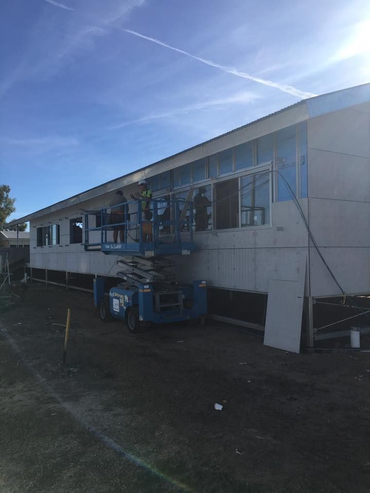A Building Under Construction With a Blue Lift in Front of It — LVL Constructions in Newcastle, NSW