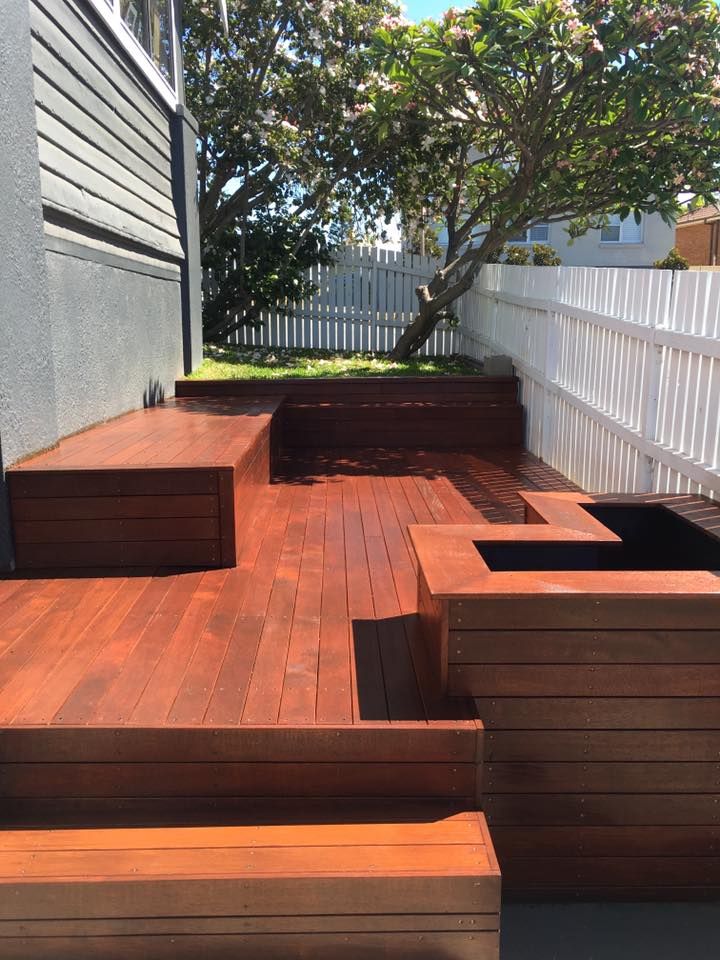A Wooden Deck With a Bench and Planters in a Backyard — LVL Constructions in Newcastle, NSW