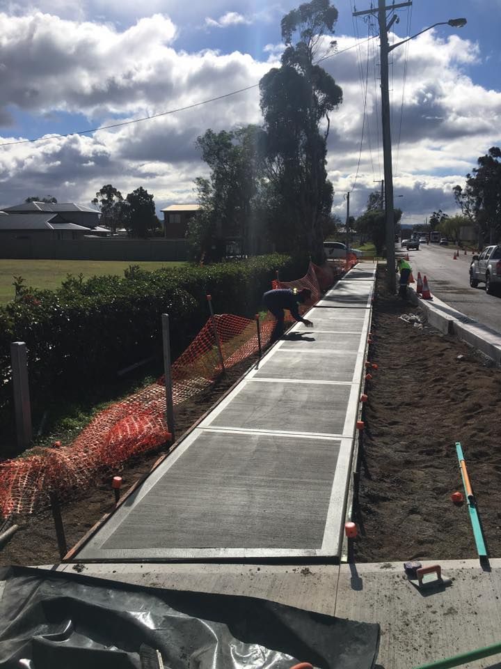 A Concrete Walkway is Being Built on the Side of a Road — LVL Constructions in Newcastle, NSW
