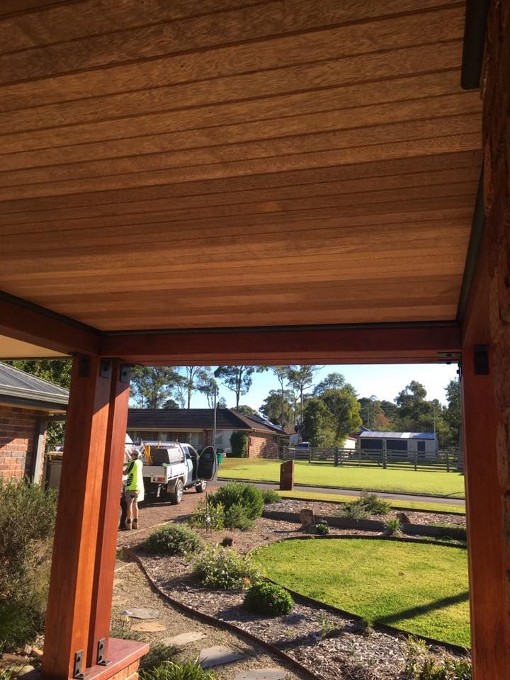 A Wooden Porch With a View of a Lush Green Yard — LVL Constructions in Newcastle, NSW