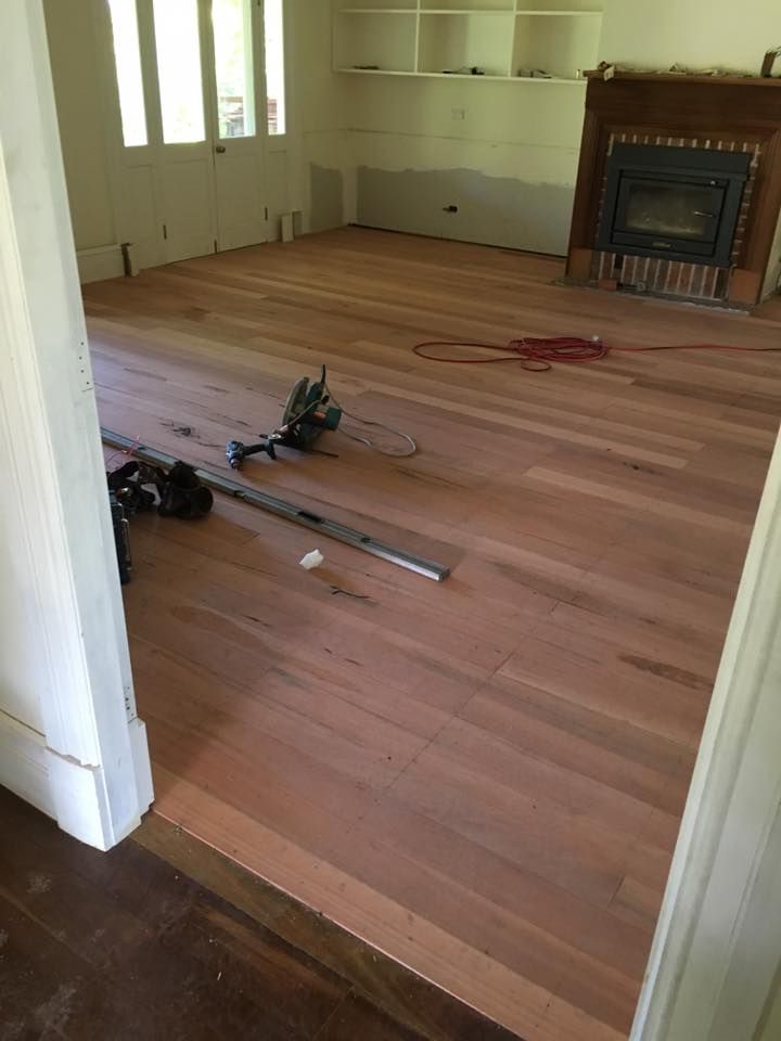 A Living Room With Hardwood Floors and a Fireplace — LVL Constructions in Newcastle, NSW