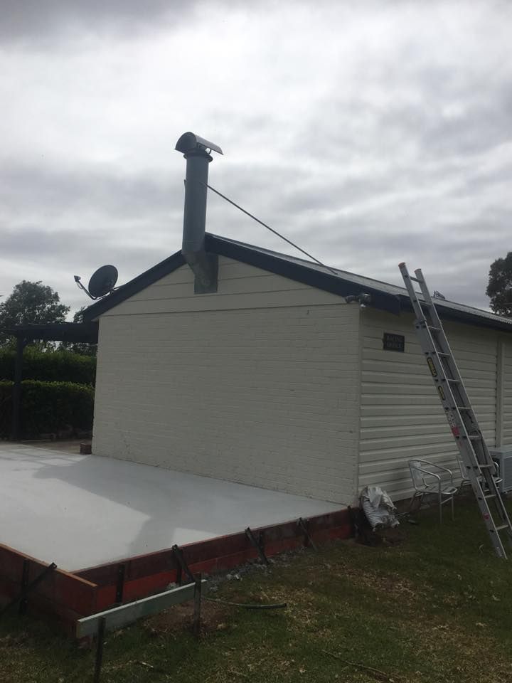 A White House With a Chimney on the Roof and a Ladder on the Side — LVL Constructions in Newcastle, NSW