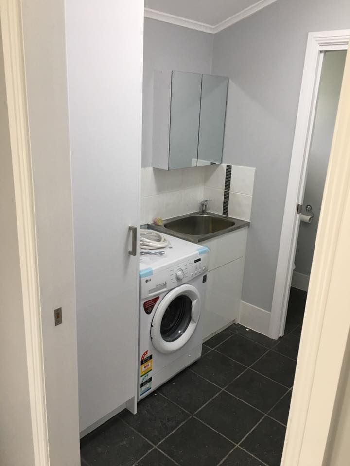 A Laundry Room With a Washer and Dryer and a Sink — LVL Constructions in Newcastle, NSW