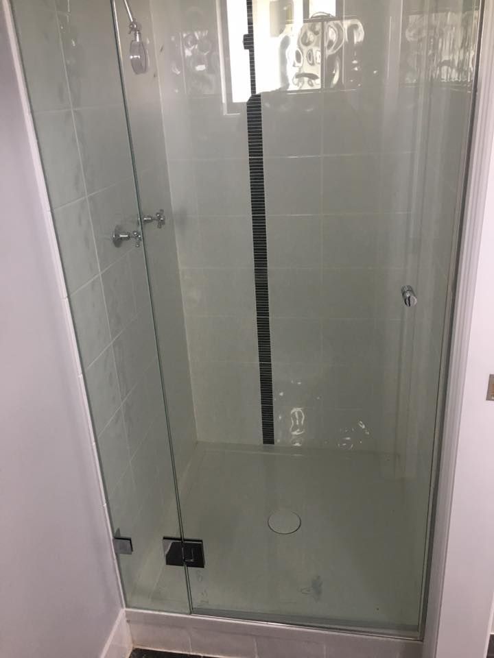 A Bathroom With a Glass Shower Door and a Tiled Floor — LVL Constructions in Newcastle, NSW