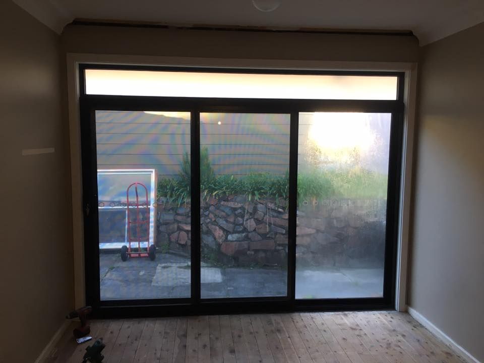 A Room With a Large Sliding Glass Door Leading to a Patio — LVL Constructions in Newcastle, NSW