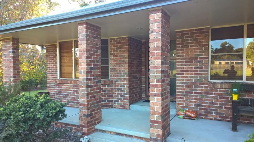 A Brick House With a Porch and Pillars — LVL Constructions in Newcastle, NSW