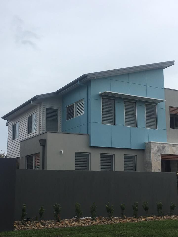 A Blue and Grey House With a Fence in Front of It — LVL Constructions in Newcastle, NSW