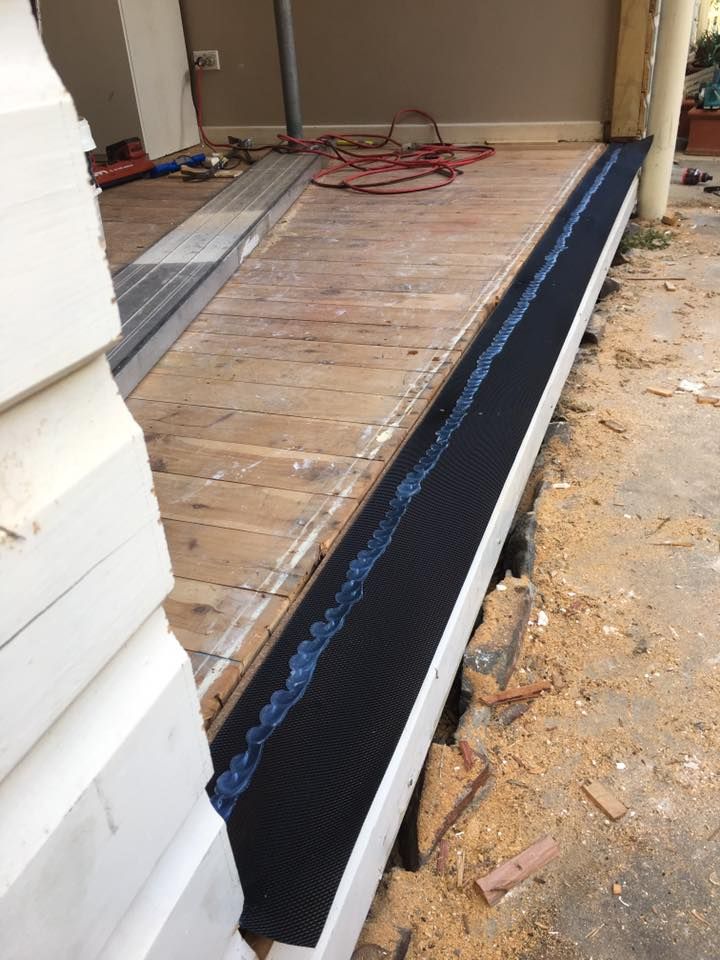 A Wooden Porch With a Black Drain on It — LVL Constructions in Newcastle, NSW