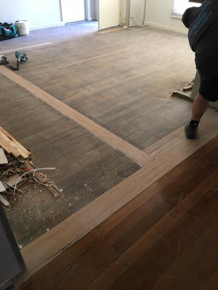A Man is Standing on a Wooden Floor in a Room — LVL Constructions in Newcastle, NSW