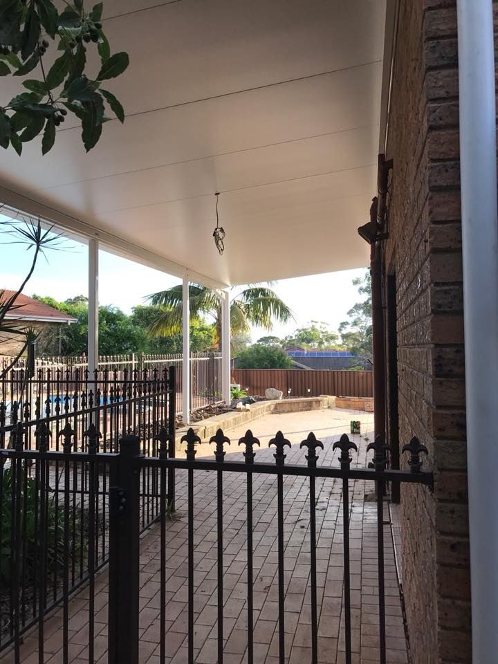 A Brick House With a White Roof and a Black Fence — LVL Constructions in Newcastle, NSW