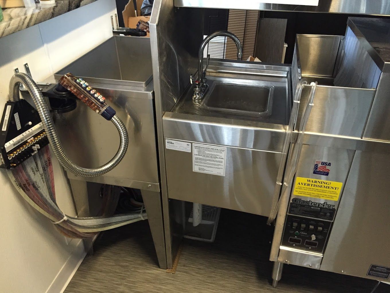 A stainless steel sink with a hose attached to it